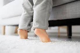 Child's bare feet on soft white carpet