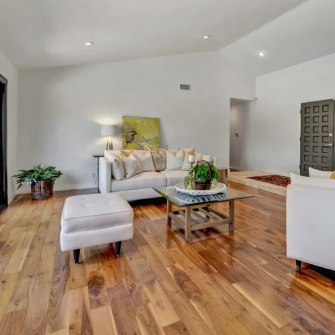 Bright living room with glossy natural hardwood flooring and white furniture